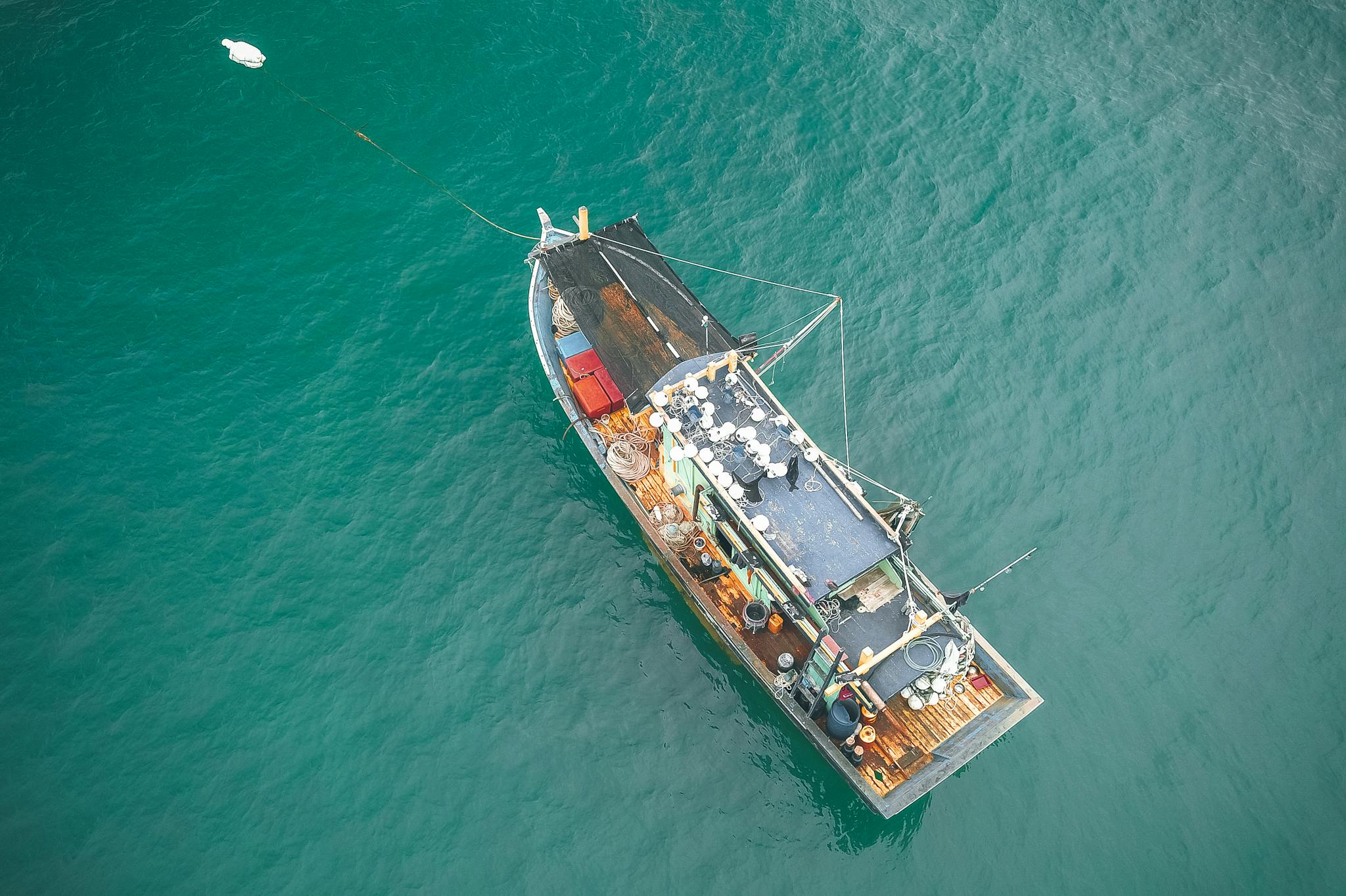 Aerial view of fishing boat floating on azure seawater